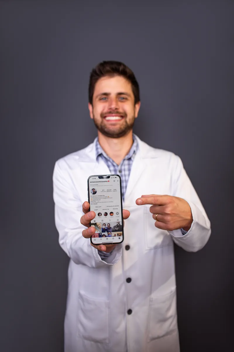 Dr. Marcos Vinícius mostrando o celular, pronto para atender pelo WhatsApp
