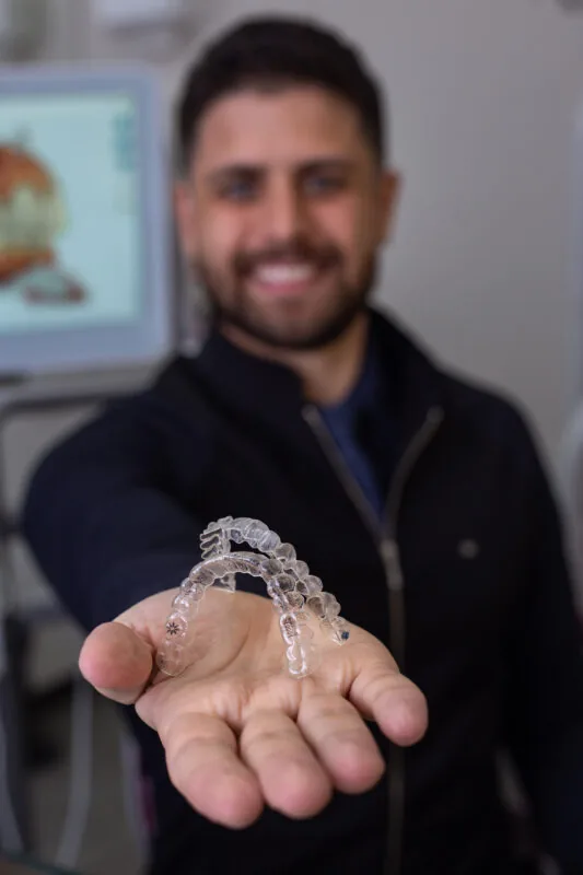 Alinhador Invisalign transparente na mão do Dr. Marcos