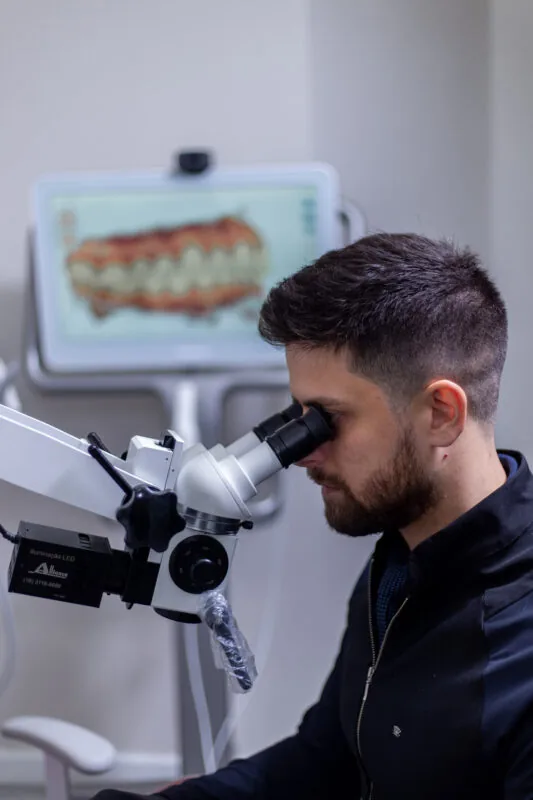 Dr. Marcos ao microscópio odontológico